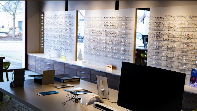 Intérieur du magasin avec ses présentoirs à lunettes et son comptoir de vente