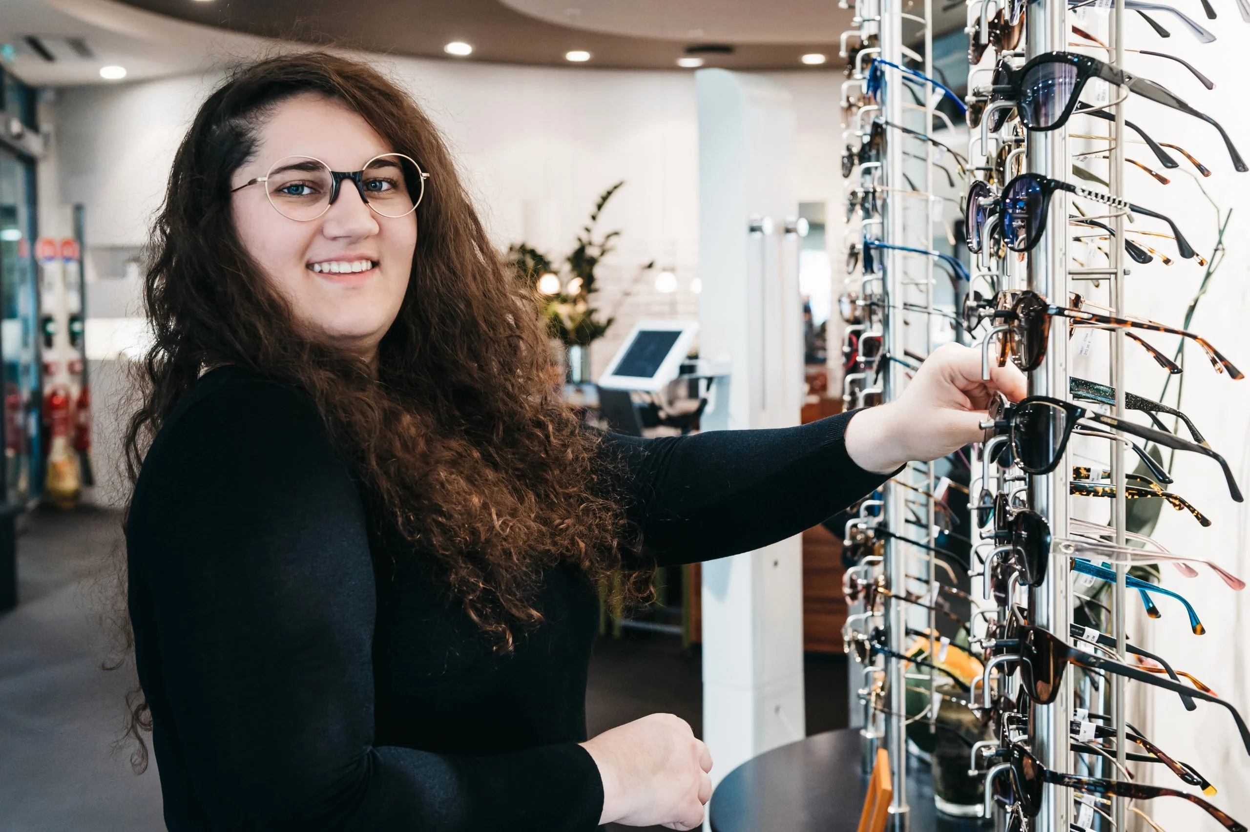 Une opticienne sélectionne des lunettes de soleil